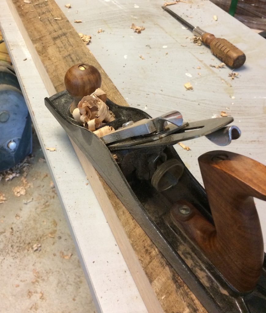 photo of a hand plane on a rough oak board